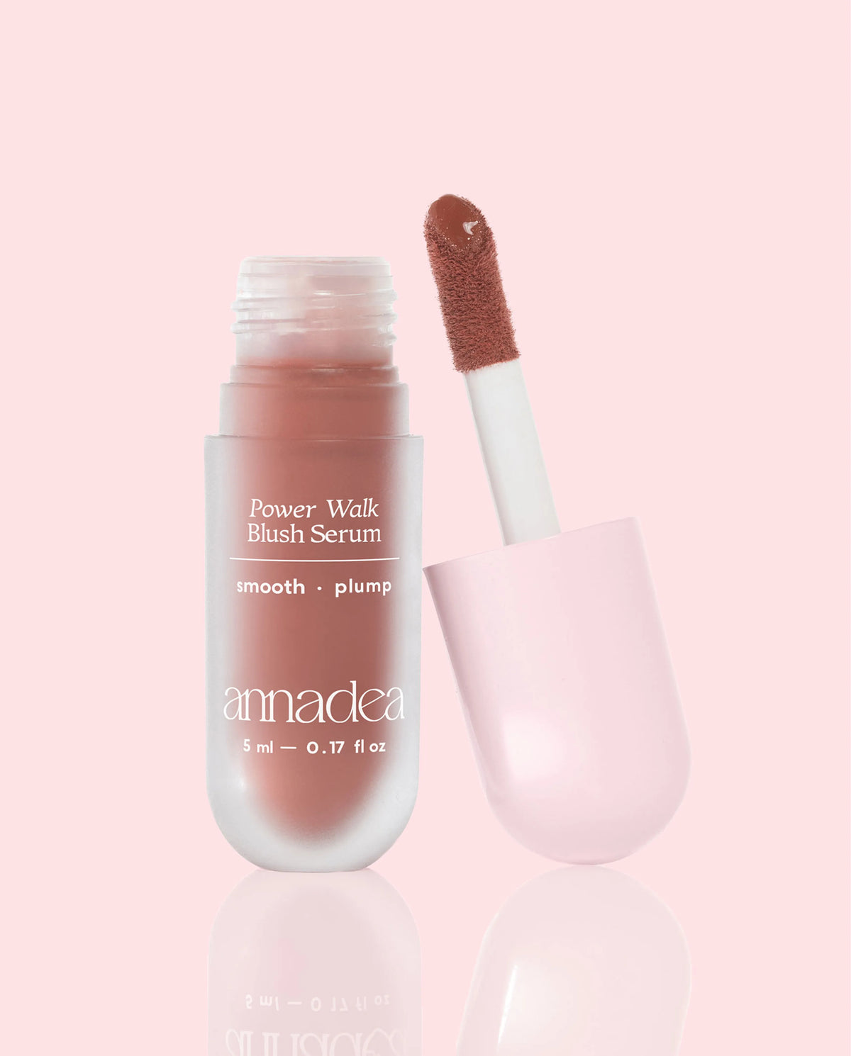 Annadea Power Walk Blush Serum in Late Date with cap removed revealing the warm terracotta pigment on the applicator wand, photographed on a soft pink background showing the smooth and plump blush serum formula