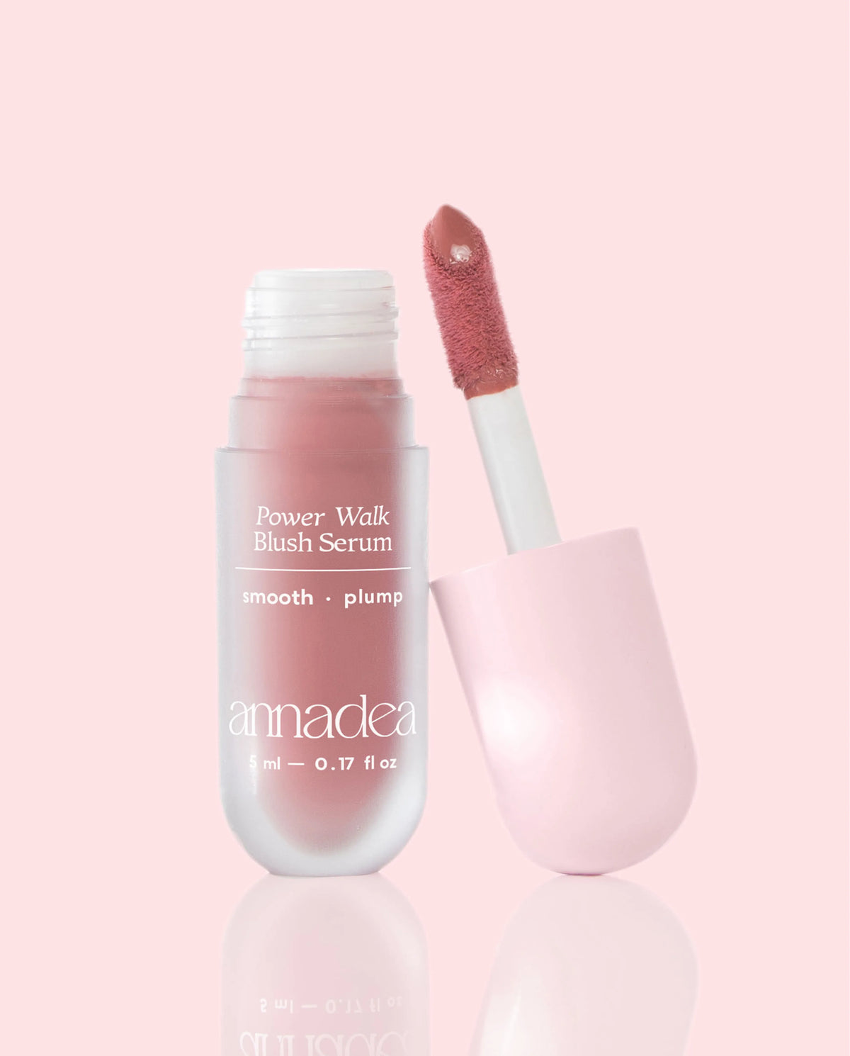 Annadea Power Walk Blush Serum in Rose Trail with cap removed revealing the dusty rose pigment on the applicator wand, photographed on a soft pink background showing the smooth and plump blush serum formula