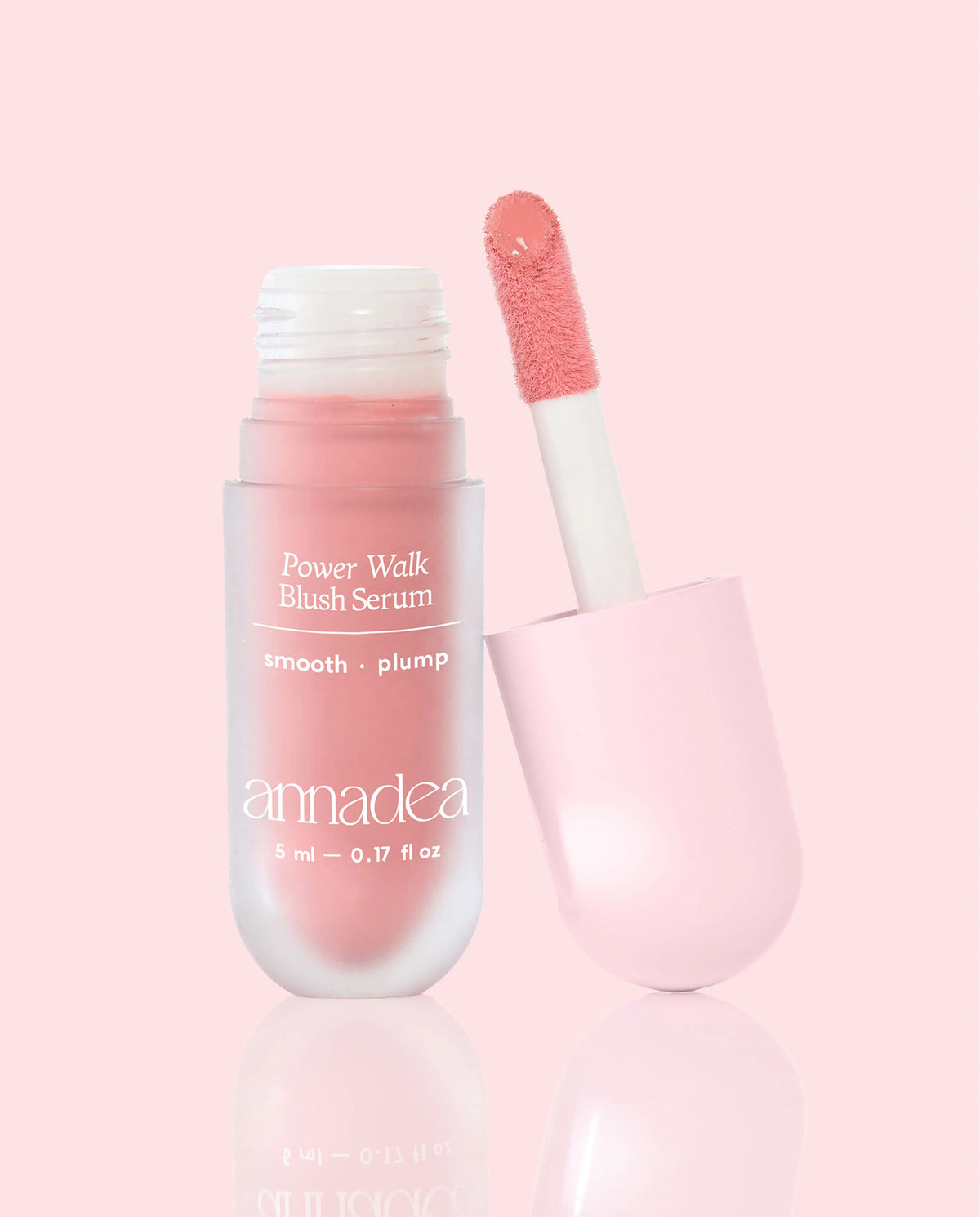 Annadea Power Walk Blush Serum in Soft Step with cap removed revealing the baby pink pigment on the applicator wand, photographed on a soft pink background showing the smooth and plump blush serum formula