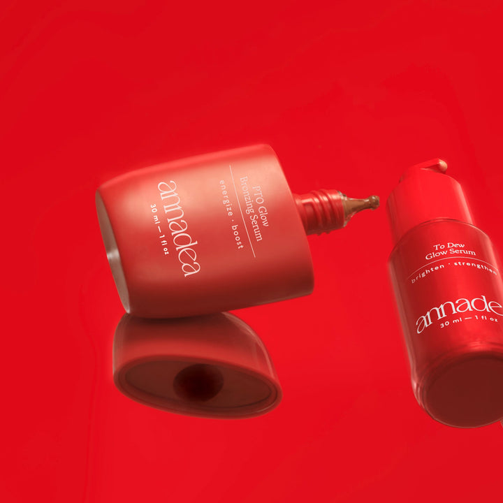 Annadea PTO Glow Bronzing Serum, To Dew Glow Serum, and Power Walk Blush Serum floating against a bold red background