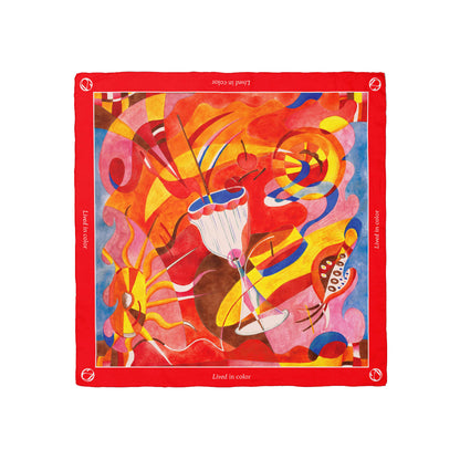Annadea Lived in Color limited-edition silk scarf flat lay showing vibrant abstract artwork by Henriette Arcelin in red, yellow, pink, and blue with red border