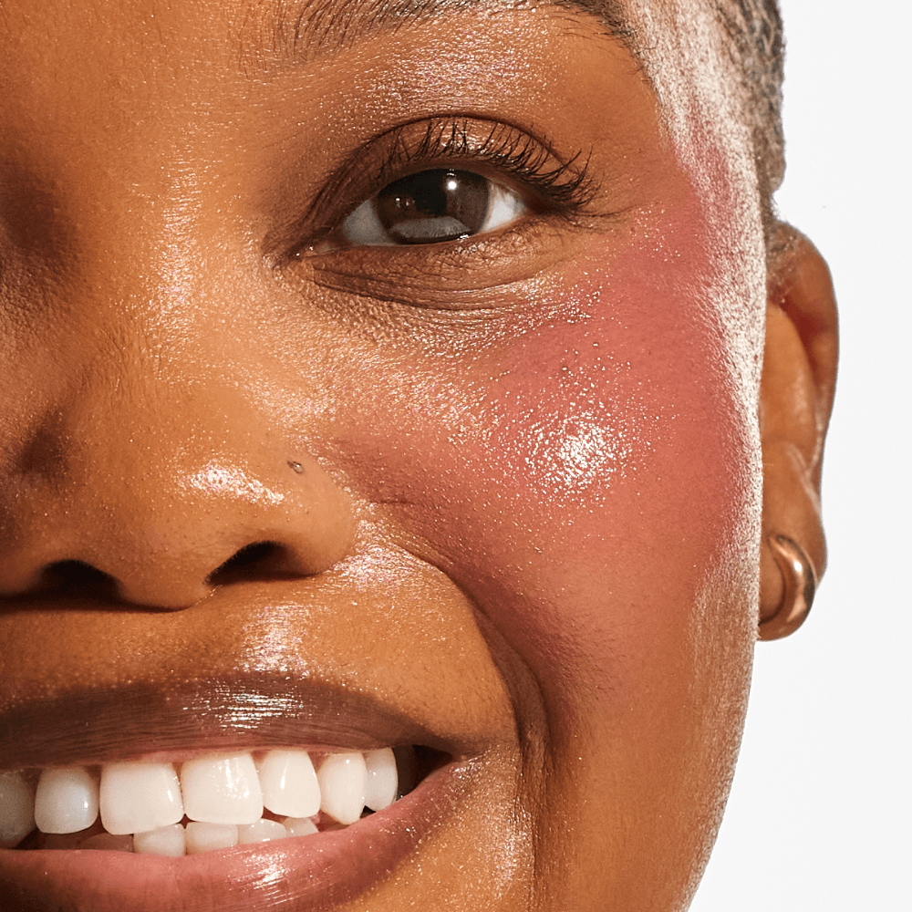 Close-up of deep skin tone showing buildable natural rosy flush on cheek from Annadea Power Walk Blush Serum in Rose Trail, a dusty neutral rose blush serum