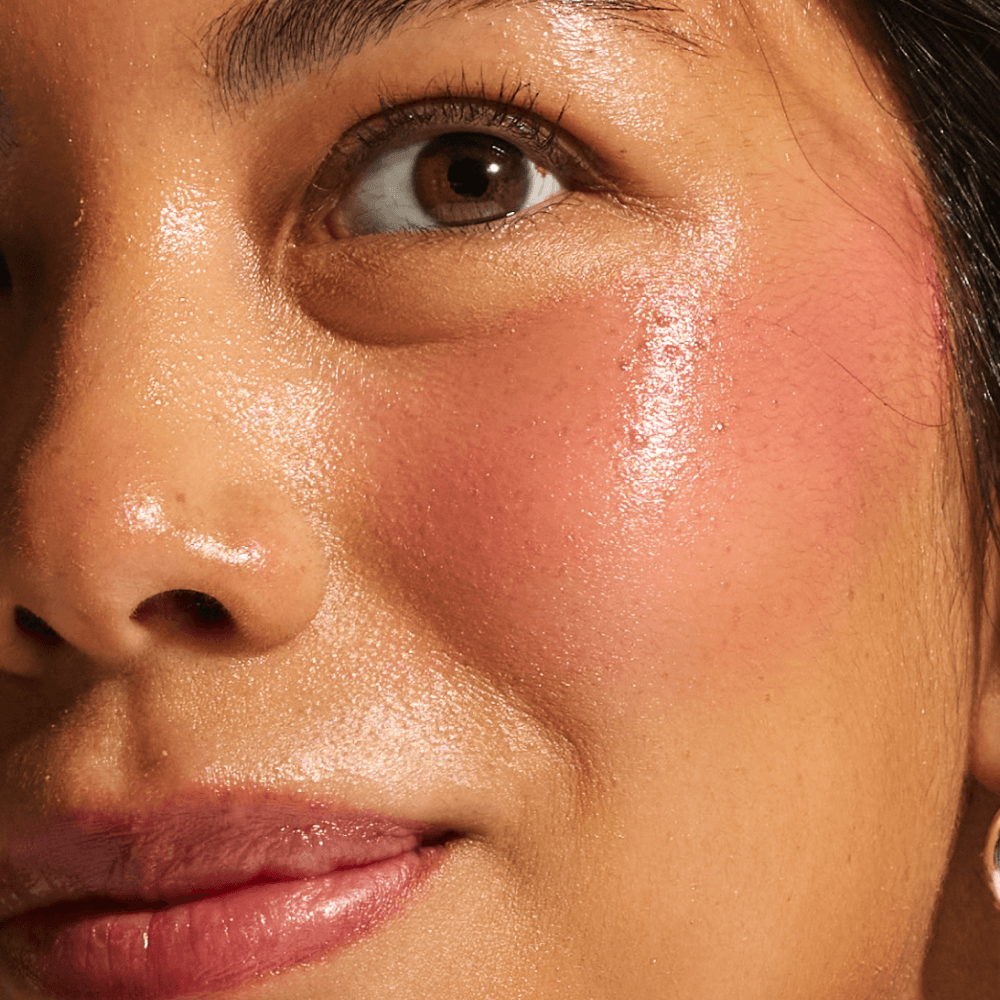 Close-up of medium skin tone showing smooth, luminous cheek texture from Annadea Power Walk Blush Serum bakuchiol and coffee seed extract antioxidant defense in Rose Trail