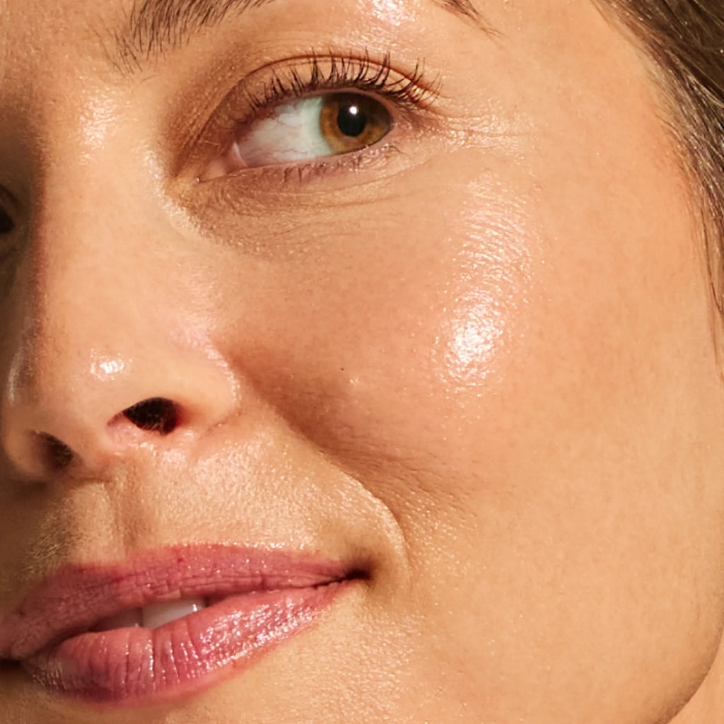 Close-up of light skin tone showing smooth, even-toned radiant skin from the Annadea PTO Glow Bronzing Serum, highlighting the niacinamide and antioxidant complex defending and refining skin texture