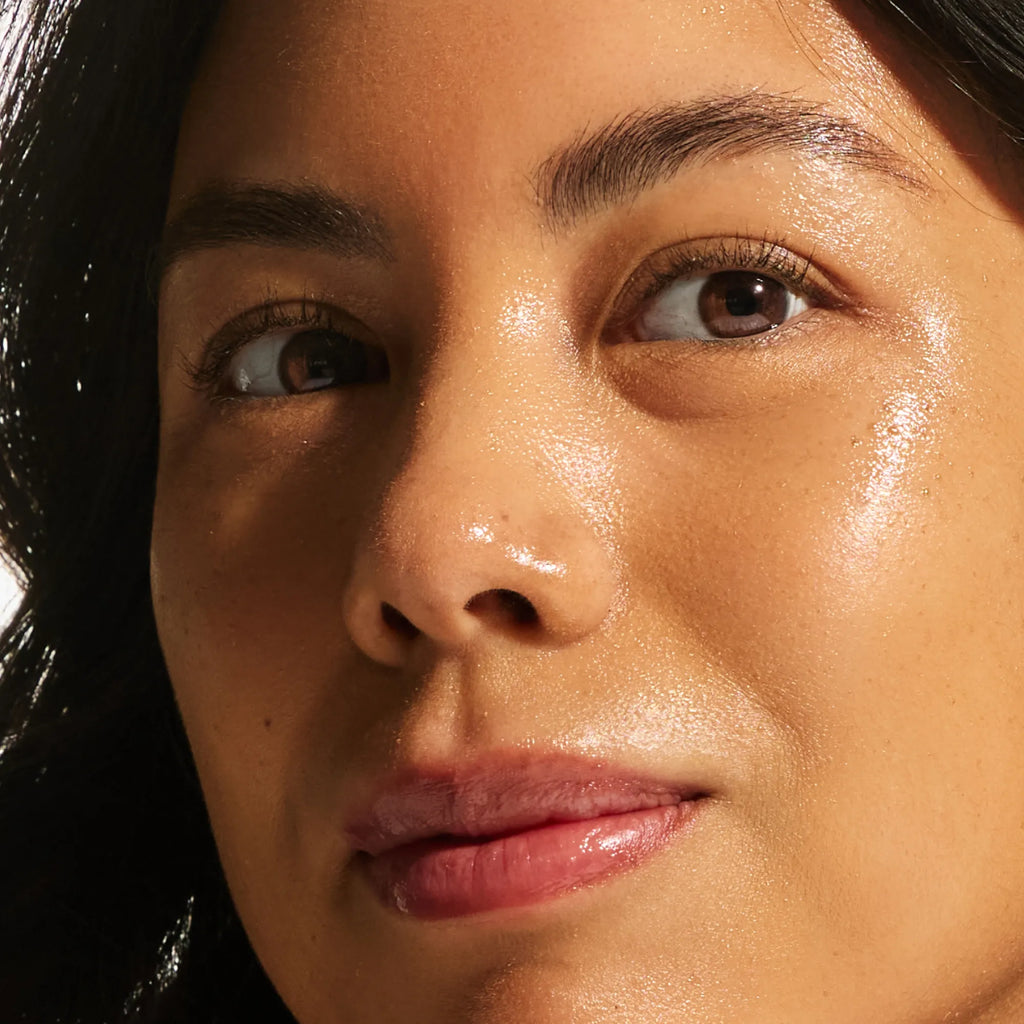 Close-up of medium skin tone showing a satin-soft, luminous complexion from the Annadea PTO Glow Bronzing Serum, reflecting the serum's nourishing skincare actives and hydrating finish
